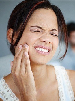 Woman holding jaw in pain