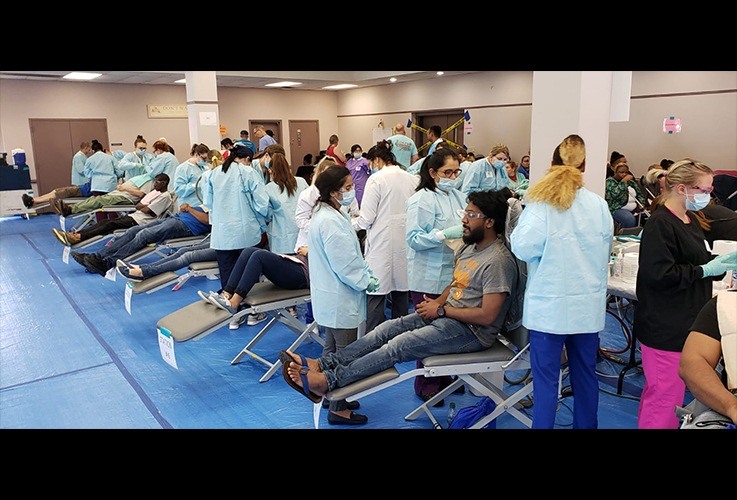 Patients in row of dental treatment chairs at community event