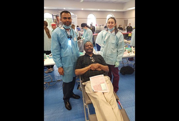 Dr. Patel with dental patient at community event