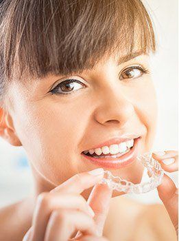 Woman placing Invisalign tray