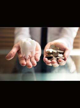 Hands holding coins and a tooth