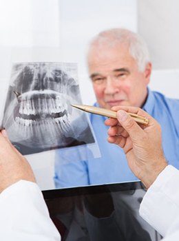 An older man examining an X-ray