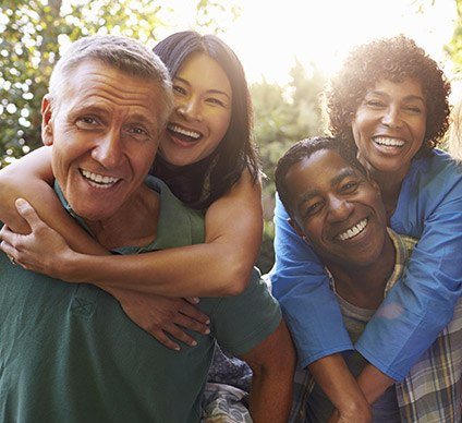 Four smiling men and women outdoors