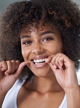 Woman flossing her teeth