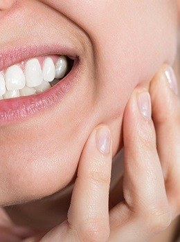 Closeup of patient holding jaw in pain