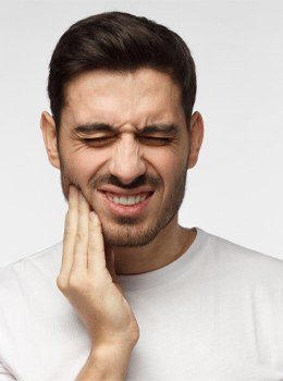 Man holding jaw in pain